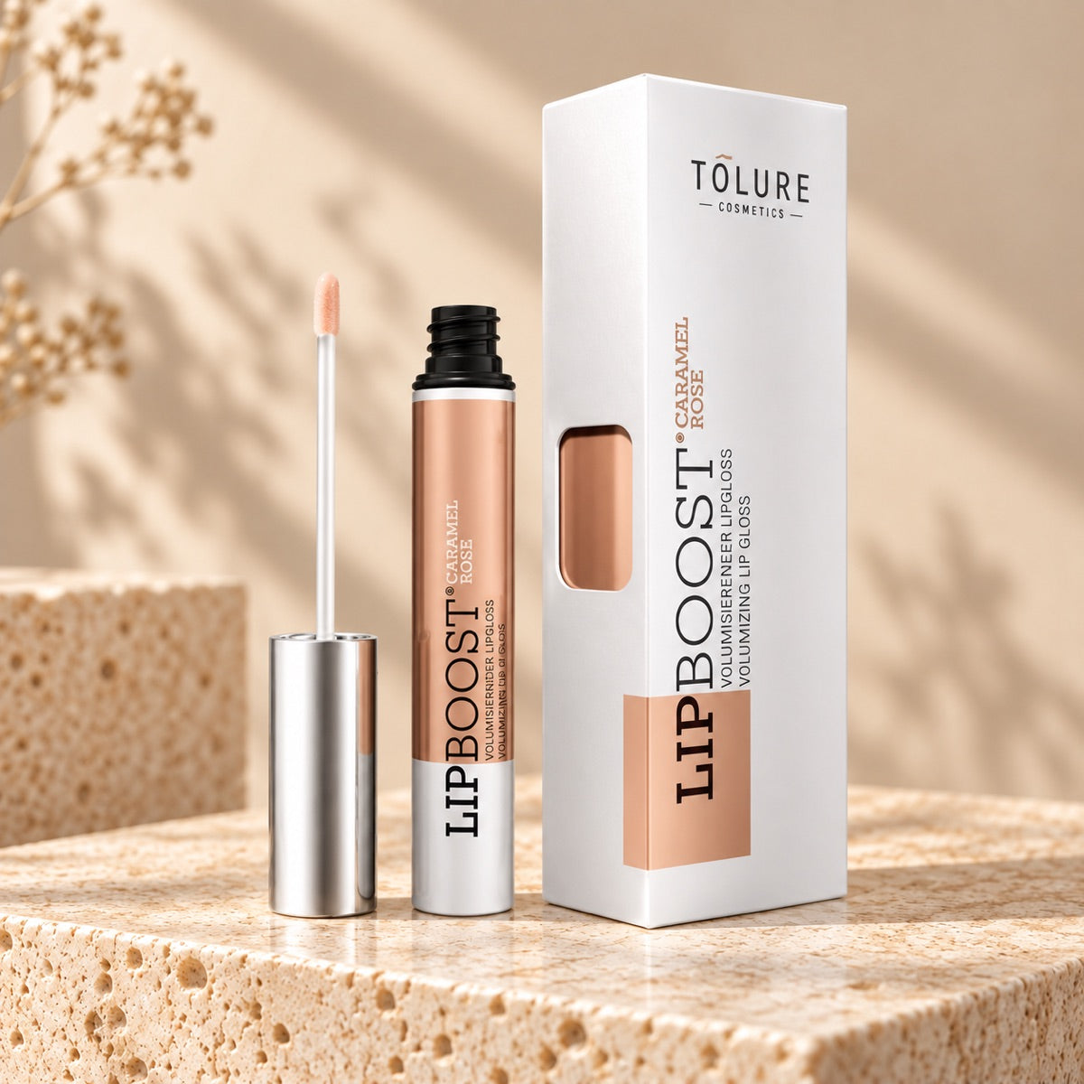Tolure LipBoost Caramel Rose lipgloss 8 ml med applikator og æske på lyst travertin.